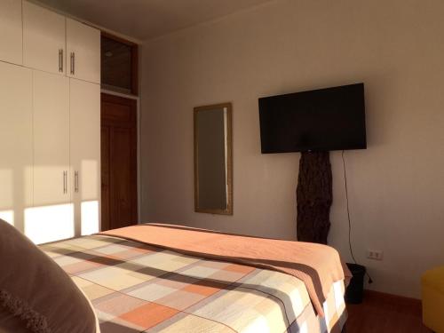 a bedroom with a bed with a flat screen tv on the wall at casa vista pacifico in Concón