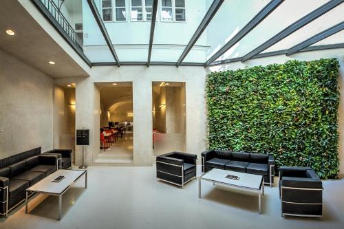 a lobby with black chairs and a green wall at Bishop's House in Prague