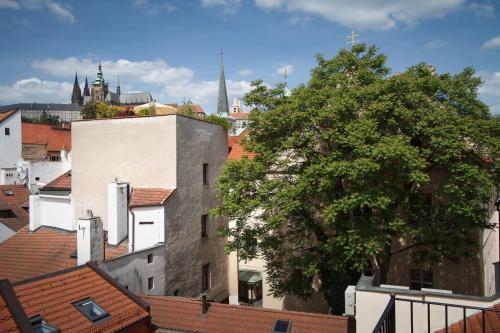 a view of a city with roofs and a tree at Bishop's House in Prague
