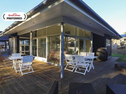 a deck with white chairs and a table on a house at Luxury Beach House with Spa - By Traum Ferienwohnungen in Hals