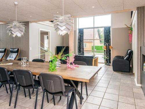 a dining room with a large wooden table and chairs at 4 star holiday home in Henne in Henne