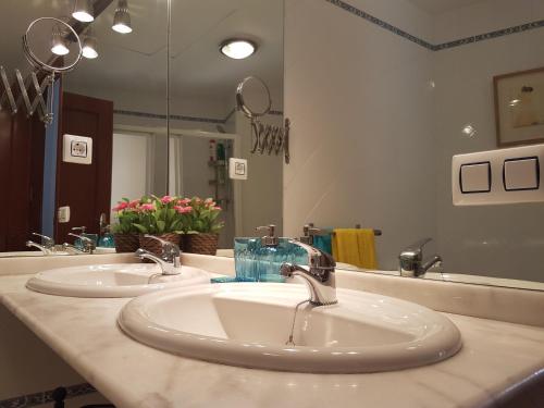 a bathroom with two sinks and a large mirror at Ático San Clemente in Seville