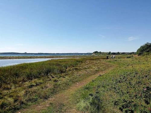 a dirt road next to a body of water at 4 star holiday home in Rønde-By Traum in Rønde
