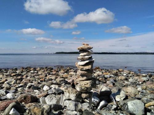 a stack of rocks on a rocky beach near the water at 4 star holiday home in Rønde-By Traum in Rønde