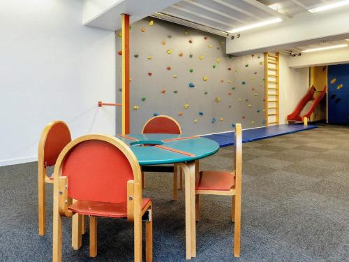 a table and two chairs in front of a climbing wall at Faaborg Holiday Centre in Fåborg