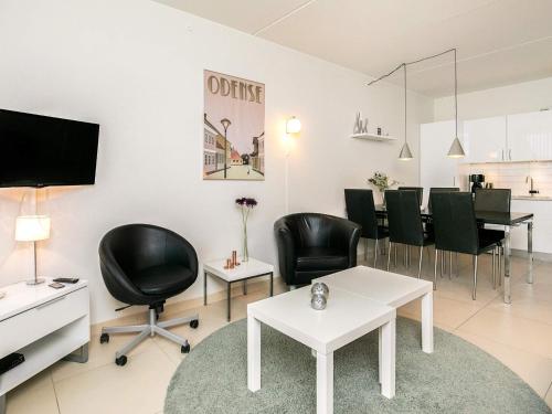 a living room with black chairs and a white table at Faaborg Holiday Centre in Fåborg