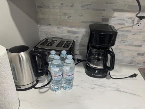 a counter with two bottles of water and a coffee maker at Cozy 3-Bedroom Basement Suite with Private Entrance in Winnipeg