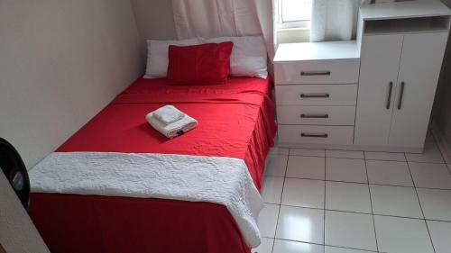 a small bedroom with a red and white bed at Apartamento aconchegante in Ananindeua