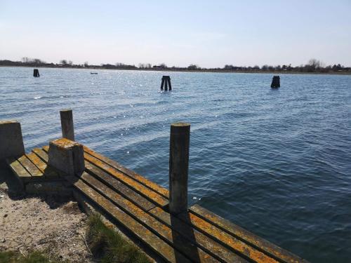 a bench sitting on the edge of a body of water at 6 person holiday home in Marstal in Marstal