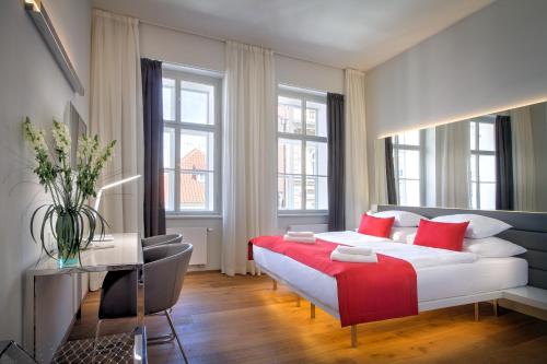 a bedroom with a large white bed with red pillows at Bishop's House in Prague