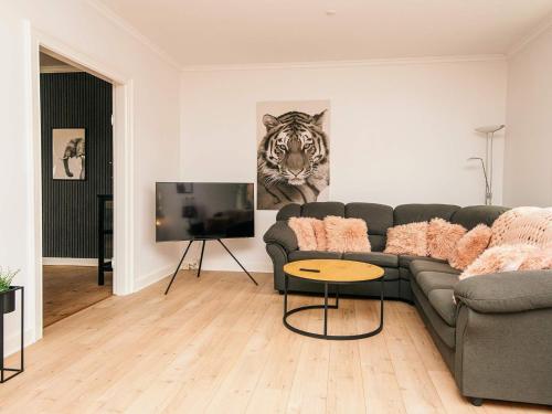 a living room with a couch and a television at 4 star holiday home in Nørre Nebel in Nørre Nebel