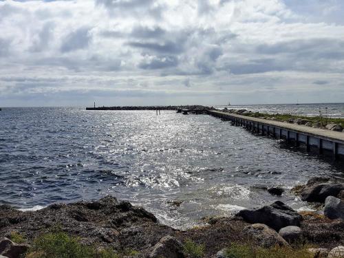 a pier stretches out into the water on a cloudy day at 4 person holiday home in Karrebæksminde in Karrebæksminde