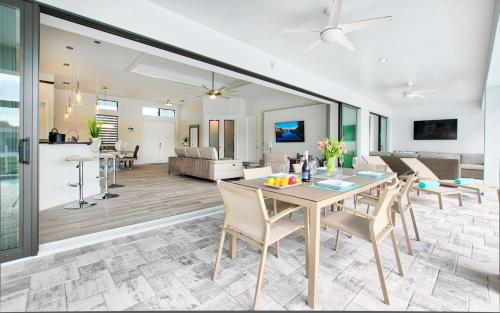 Un comedor y una sala de estar con mesa y sillas. en Villa White Pearl, en Matlacha