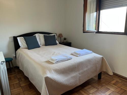 a bedroom with a bed with two towels on it at Casa da Laija - Vistas rio, campo e montanha in Cova