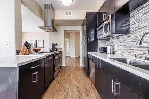 a large kitchen with black cabinets and a sink at Spacious 3-Bedroom 3BTH Apt in Marina Del Rey! Pool, Hot Tub in Los Angeles