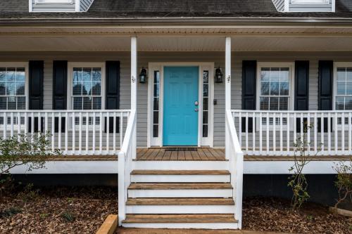 a white house with a blue door and stairs at 23 Magnolia Rydal in Rydal