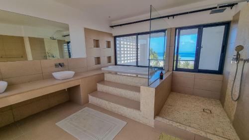 モンバサにあるPenthouse with Stunning Beachfront Viewsのシャワーと洗面台と窓のあるバスルーム
