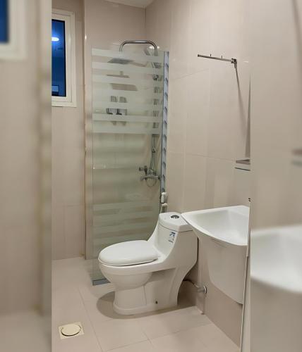 a white bathroom with a toilet and a sink at المنظر الجميل للشقق الفندقية in Al Jubail