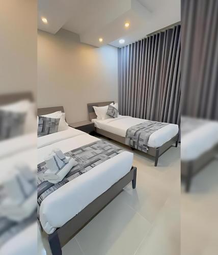 a bedroom with two beds and a window at المنظر الجميل للشقق الفندقية in Al Jubail
