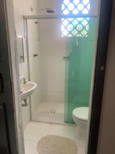 a bathroom with a shower and a toilet and a sink at Quarto cop 30 in Belém