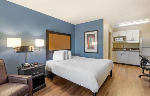 a bedroom with a large white bed and a kitchen at Extended Stay America Suites - Chesapeake - Crossways Blvd in Chesapeake