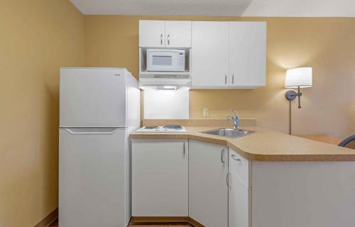 a kitchen with white cabinets and a white refrigerator at Extended Stay America Suites - Columbia - Laurel - Ft Meade in Jessup
