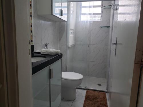 a white bathroom with a toilet and a shower at Refugio Executivo Litoral in João Pessoa