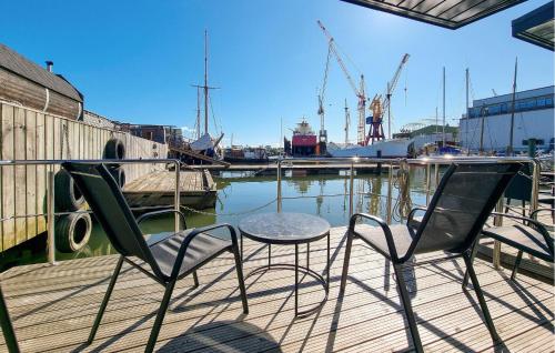 two chairs and a table on a dock with a marina at Stunning Ship In Göteborg With Sauna in Gothenburg