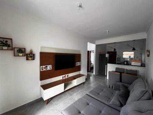 Una sala de estar con un sofá y un televisor de pantalla plana. en Casa Diamante, en Angelim