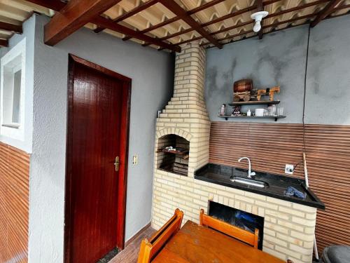 une pièce avec une cheminée en briques et une porte rouge dans l'établissement Casa Diamante, à Angelim