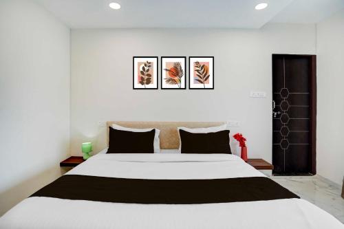 a bedroom with a large white bed with black pillows at Hotel O Omkar Nagar Nagpur in Nagpur