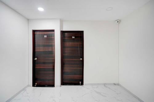 two doors in a room with white walls at Hotel O Omkar Nagar Nagpur in Nagpur