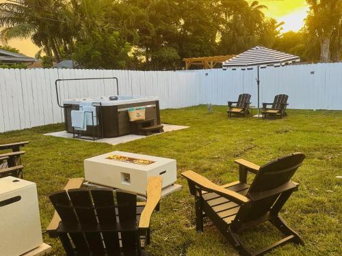 a backyard with two chairs and a grill and a table at Wilton Manors Guesthouse in Fort Lauderdale