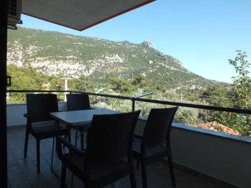 a table and chairs on a balcony with a mountain at Tuana Suit Apart in Kas
