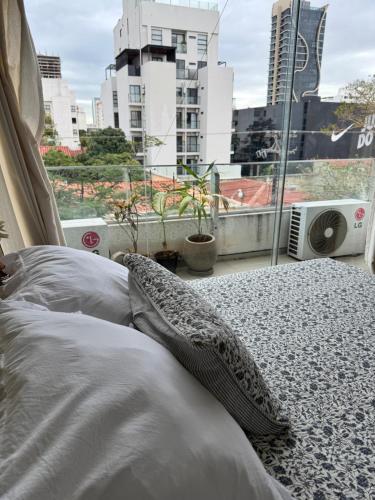 two pillows on a bed in a room with a window at Confortable Monoambiente Equipetrol in Santa Cruz de la Sierra