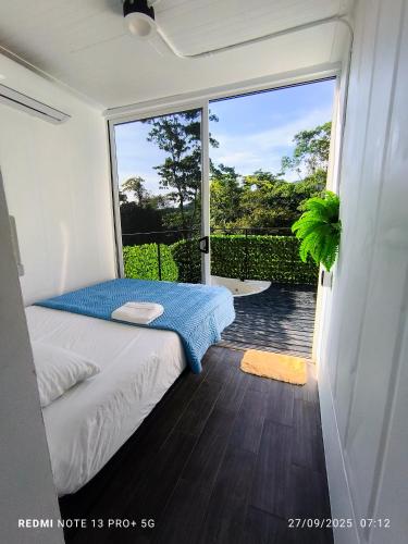 a bedroom with a bed and a sliding glass door at Tucan container in Fortuna