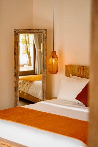 a bedroom with a mirror and a bed at Villa Kayu in Gili Air