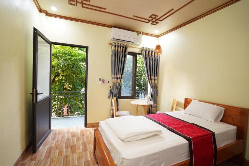 ニンビンにあるTam Coc Riverside Homestayのベッドと大きな窓のある寝室