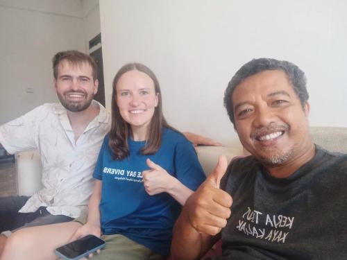 two men and a woman sitting on a couch giving a thumbs up at Sony homestay in Komodo Labuan Bajo Airport