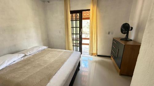 Un dormitorio con una cama y una cómoda y una ventana. en Sobrado charme da Chappada, en Rio de Contas