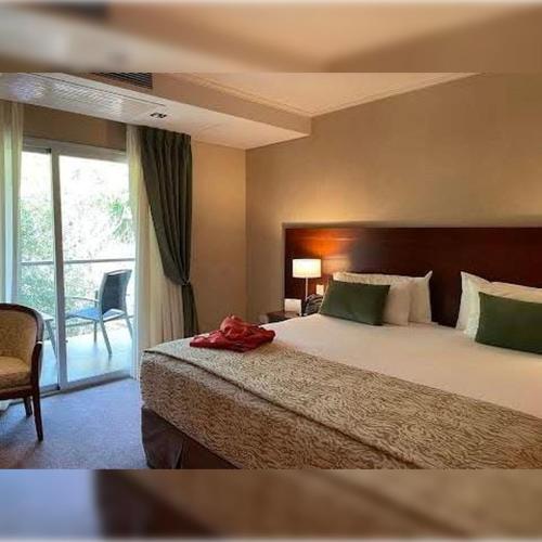 Una habitación de hotel con una cama y una ventana. en Iguazu Hotel, en Puerto Iguazú
