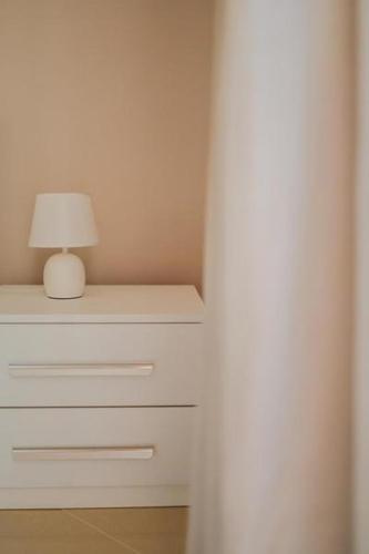a white dresser with a lamp on top of it at Mare Magnum in Castellammare di Stabia