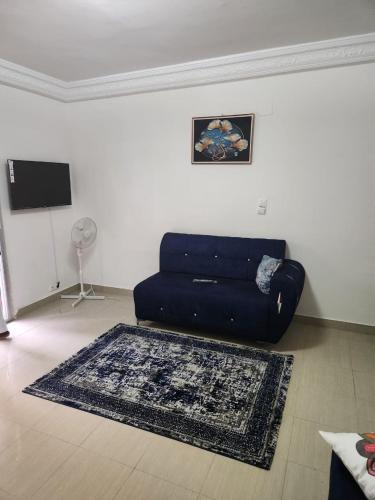 a living room with a blue couch and a rug at Ramo in Dakar