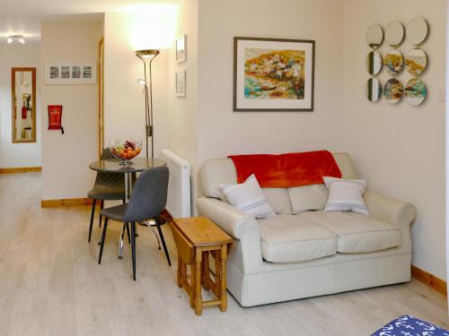 a living room with a white couch and a table at The Honeypot in Padstow
