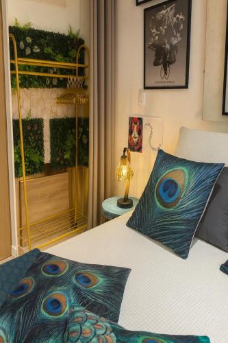a bedroom with a bed with a peacock pillow at Studio Palais des Festivals - Centre Ville - Plages - Commerces - Internet Fibre in Cannes