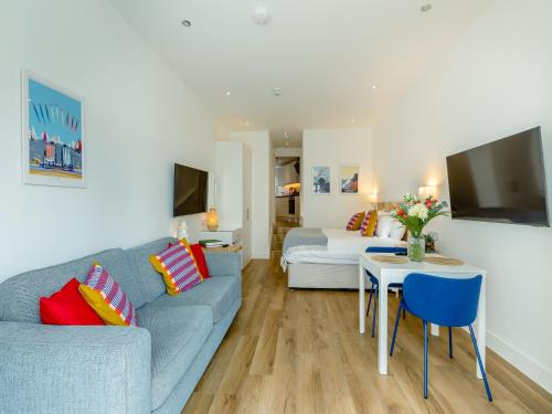 a living room with a couch and a table at Belgrave Sands Apartment in Torquay