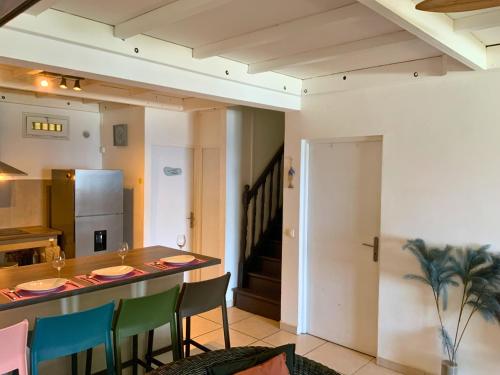 eine Küche und ein Esszimmer mit Tisch und Stühlen in der Unterkunft Maison Bleu-Oxygène in Saint-Joseph