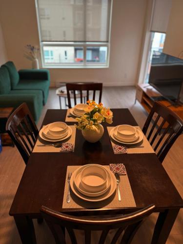 a dining room table with plates and flowers on it at Victoria Colwood Place in Colwood