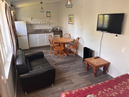 a living room with a couch and a table at Westshore Holiday Park in Napier