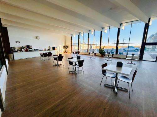 una grande stanza con tavoli, sedie e finestre di Super 8 by Wyndham Sterling CO a Sterling